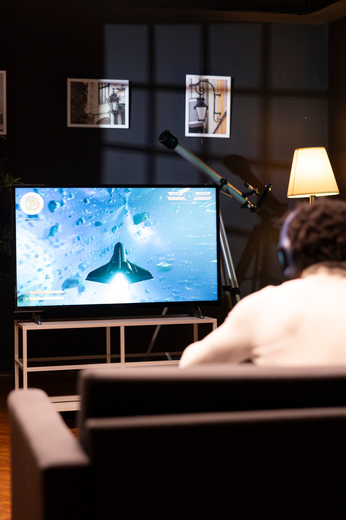 Gamer in front of widescreen smart TV watching SF videogame gameplay